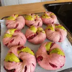 Freshly baked Raspberry Pistachio Sourdough Bagels cooling on a rack