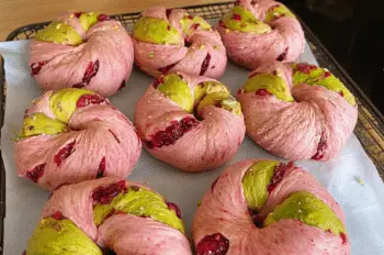 Freshly baked Raspberry Pistachio Sourdough Bagels cooling on a rack