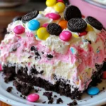 Layer of crushed Oreo cookies for Easter Dirt Cake Casserole in a glass dish