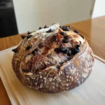 Freshly baked chocolate marbled sourdough bread with chocolate chips on a wooden cutting board