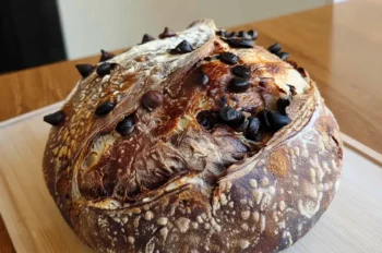 Freshly baked chocolate marbled sourdough bread with chocolate chips on a wooden cutting board
